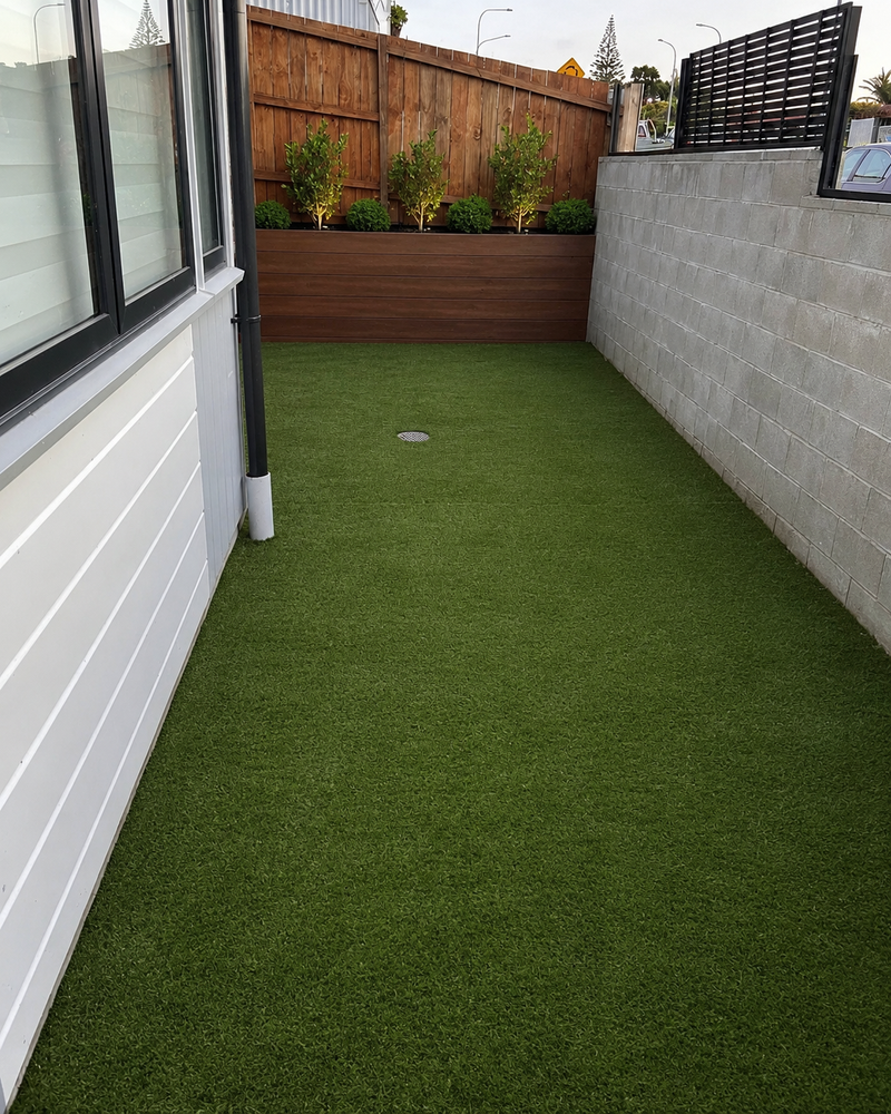 Artificial turf installation in a narrow side yard with timber garden edging and low maintenance landscaping at a Melbourne home.