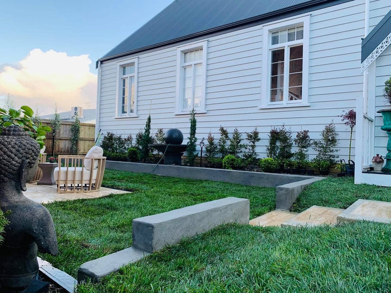 Residential landscaping with garden edging, manicured lawn, planting and paved outdoor entertaining area.
